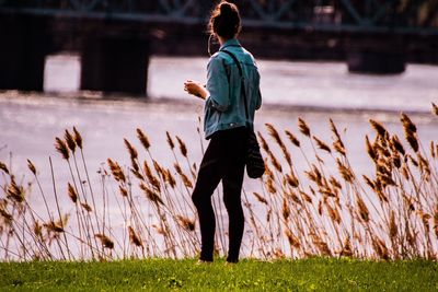 Women standing on field by lake