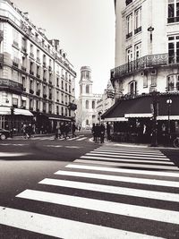 People walking on street in city against clear sky