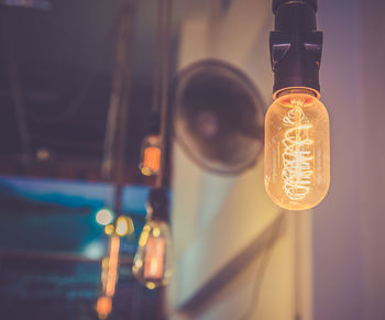 Low angle view of illuminated light bulbs hanging