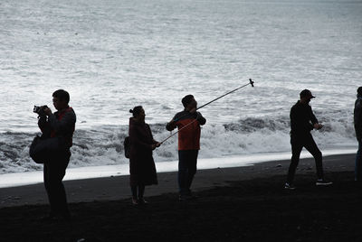 Group of people fishing on beach