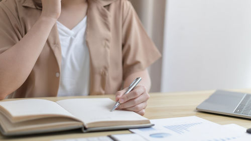 Midsection of businesswoman working at office