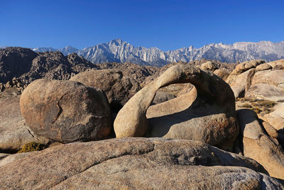 Rock formations on landscape against clear blue sky