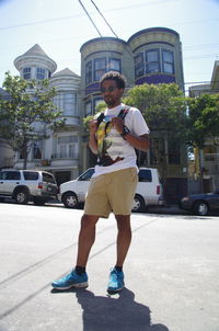 Young man using mobile phone on city street