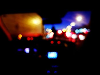 Defocused image of illuminated car in city at night