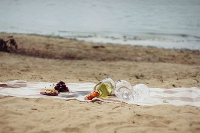 Close-up of water bottle on sand at beach