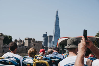 People in front of buildings against clear sky