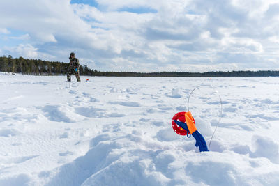 Fishing rod on the ice in winter river sunny day, blue sky. winter fishing