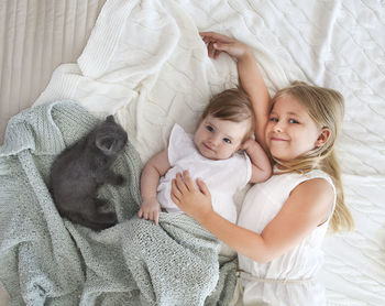 Full length of mother and baby girl on bed