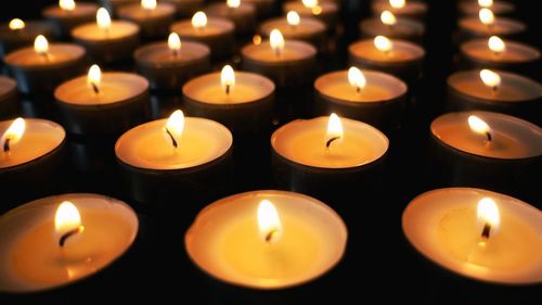 Close-up of illuminated candles in temple