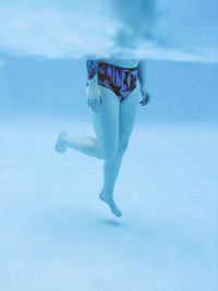 Full length of woman jumping against blue sky