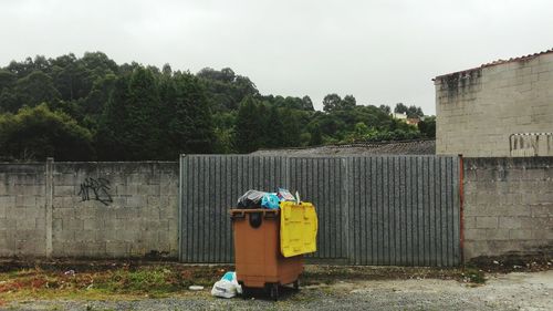 Abandoned garbage by trees against built structure