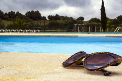 Sunglasses next to the swimming pool