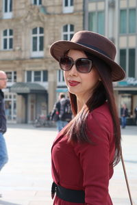 Portrait of woman wearing sunglasses while standing in city