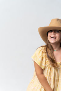 Stylish girl in yellow dress and yellow hat on white background