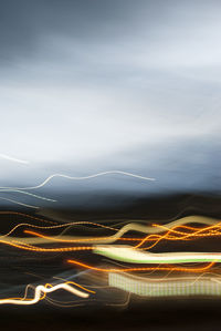 Light trails on road against sky at night