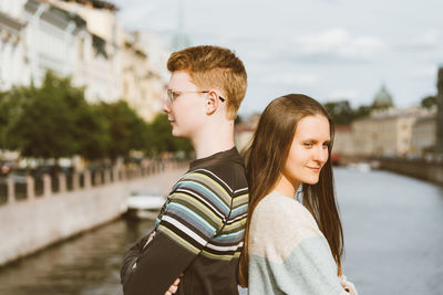 Portrait of young couple standing in city