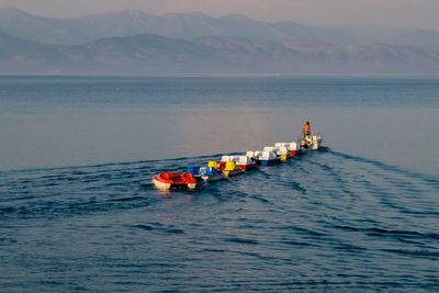 People on boat in sea against sky