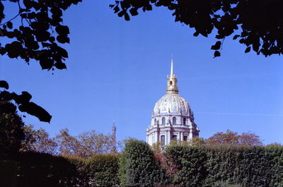 View of trees and building against blue sky