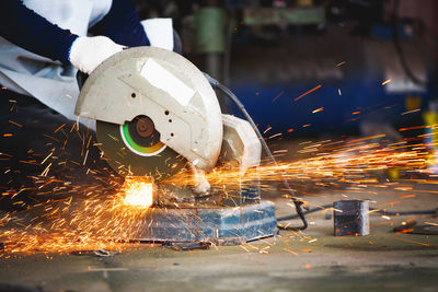 Cutting of a steel with splashes of sparks, metal processing with angle grinder. 