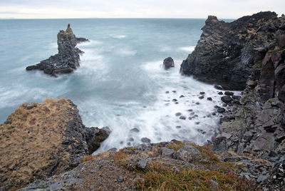 Scenic view of rocks in sea against sky