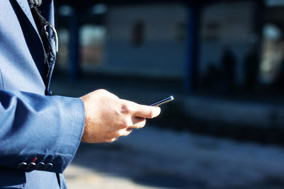 Close-up of businessman using smart phone at the station.