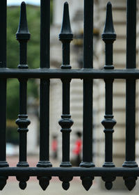 Full frame shot of metal railing and a blurred guard. 