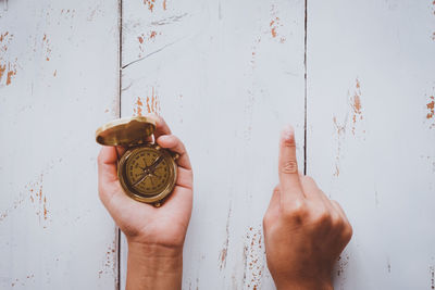 Cropped hands with navigational compass on table