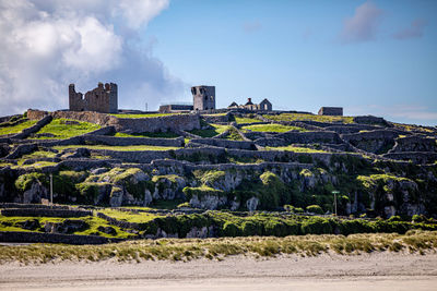 Panoramic view of old 15th century ruined castle buildings against sky, prehistoric stone fort