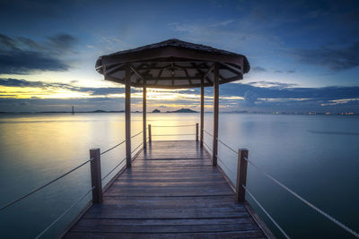 Pier over sea against sky during sunset