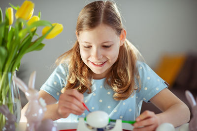 Portrait of young woman blowing bubbles at home