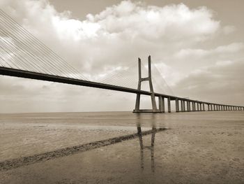 View of suspension bridge against cloudy sky