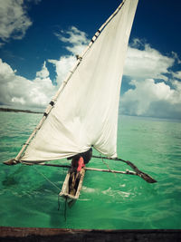 Men sailing on outrigger boat in sea