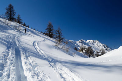 Scenic view of snow covered mountains against blue sky