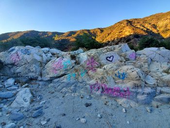 View of rocks and mountains against clear blue sky