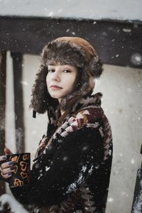 Portrait of woman holding a cup of coffee while it snows