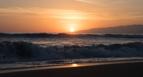 California sunset over pacific ocean waves with malibu in the distance