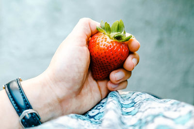 Cropped image of hand holding strawberry