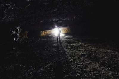 Man walking in illuminated lights against sky at night