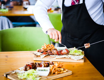 Midsection of man preparing food at restaurant