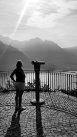 Full length of woman standing on railing against sea