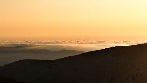 Scenic view of silhouette mountains against sky during sunset