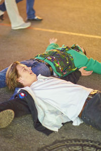 Drunk men lying on road at amusement park during night