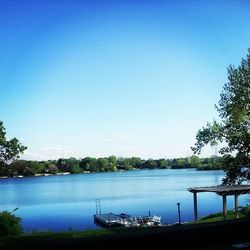 Calm lake against clear blue sky