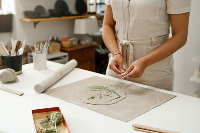 Pottery workshop in studio. person working with clay by the table. adults learning to do ceramic