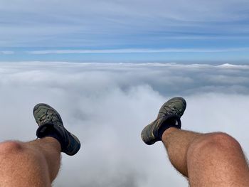 Low section of man by sea against sky