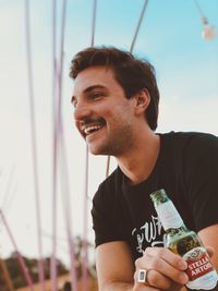 Portrait of young man drinking beer bottle