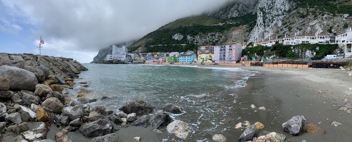 Panoramic shot of river by buildings against sky