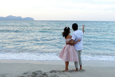 Rear view of women standing on beach