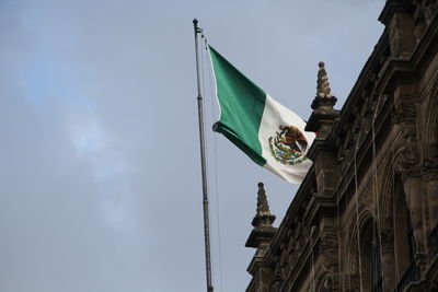 Low angle view of flag on building against sky