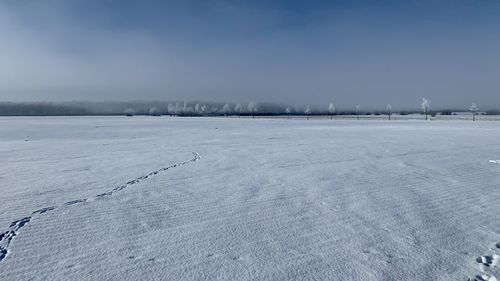 Snow covered field against sky